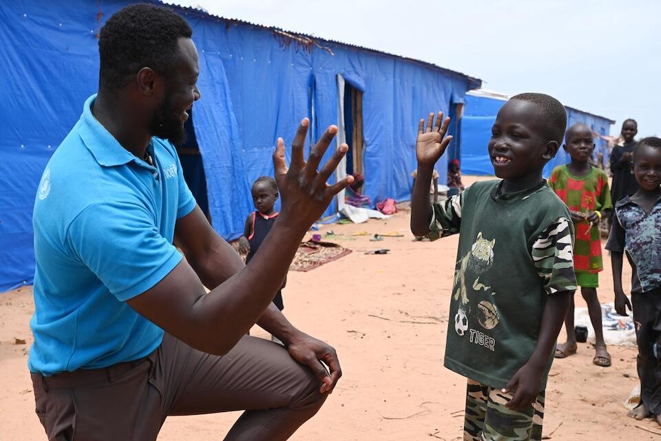 A UNICEF Staff member with a boy at the Ourang site for refugees in eastern Chad, close to the border of Sudan.