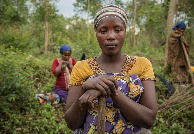 Woman stands facing the camera among the Tupendane group members.