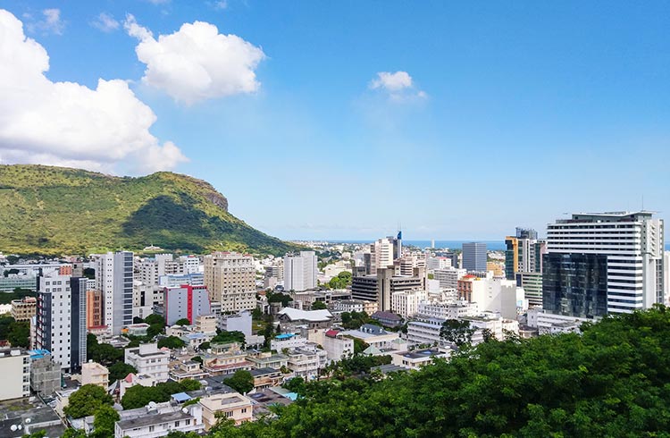 Buildings in Port Louis with green mountains in the background