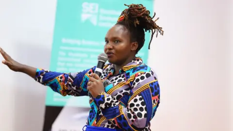 Dr Joyce Kimutai Dr Joyce Kimutai delivers a talk, while holding a microphone