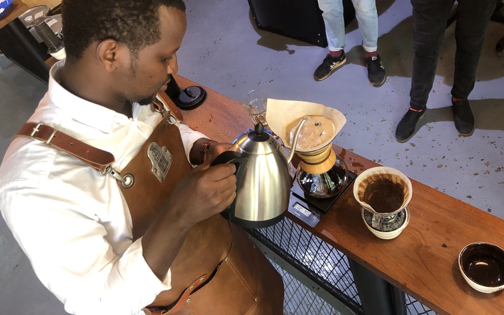 A Rwandan barista brews a Chemex.