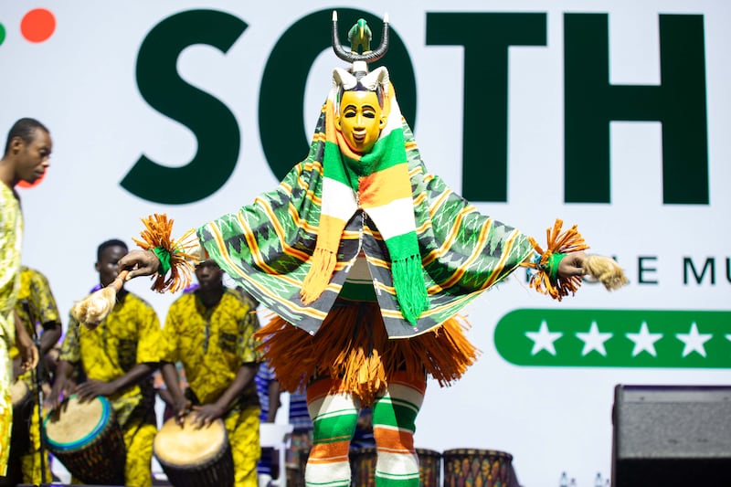 The Sotheca traditional dance troupe performs in bright yellow and green costumes at the 2024 Strengthening Families Conference in Abidjan, Ivory Coast