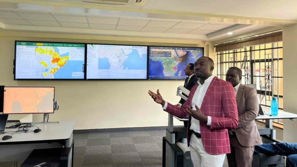 A man is standing in front of screens in ICPAC situation room