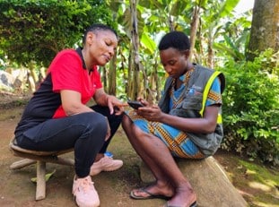 Two people sitting outside discussing how to use a reporting device