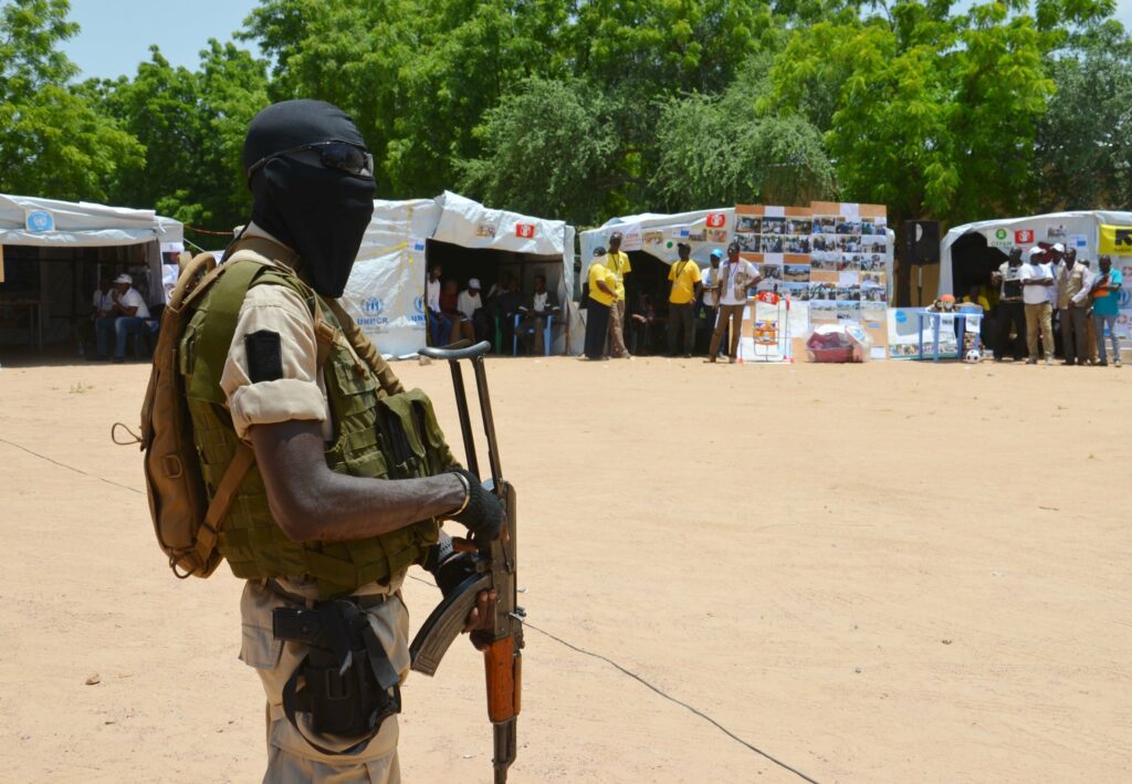 A soldier stands guard near information stands in a camp in Diffa, Niger