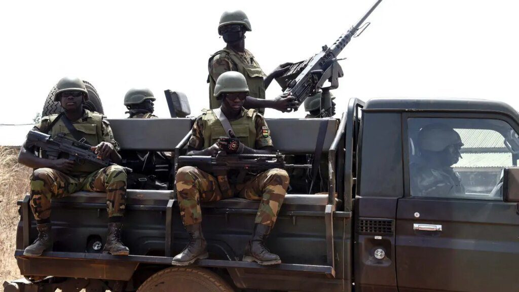 Togolese soldiers stand guard as they patrol at Namoundjoga village in northern Togo