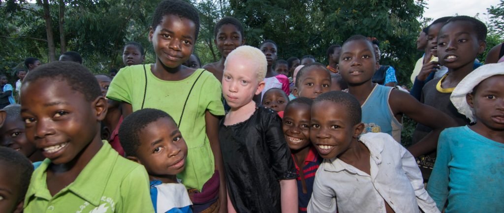 Annie Alfred (centre) and her best friend (to Annie’s left) with their peers. © LAWILINK/Amnesty International