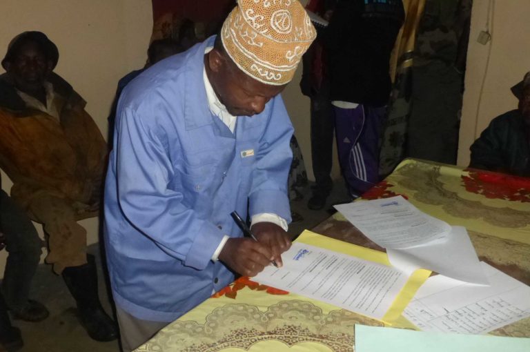 Abdourahamane signing the first agreement to preserve the Livingstone roost site at the mayor’s office in Adda in the presence of village leaders and the village forest management committee. Photo credit: Dahari. 