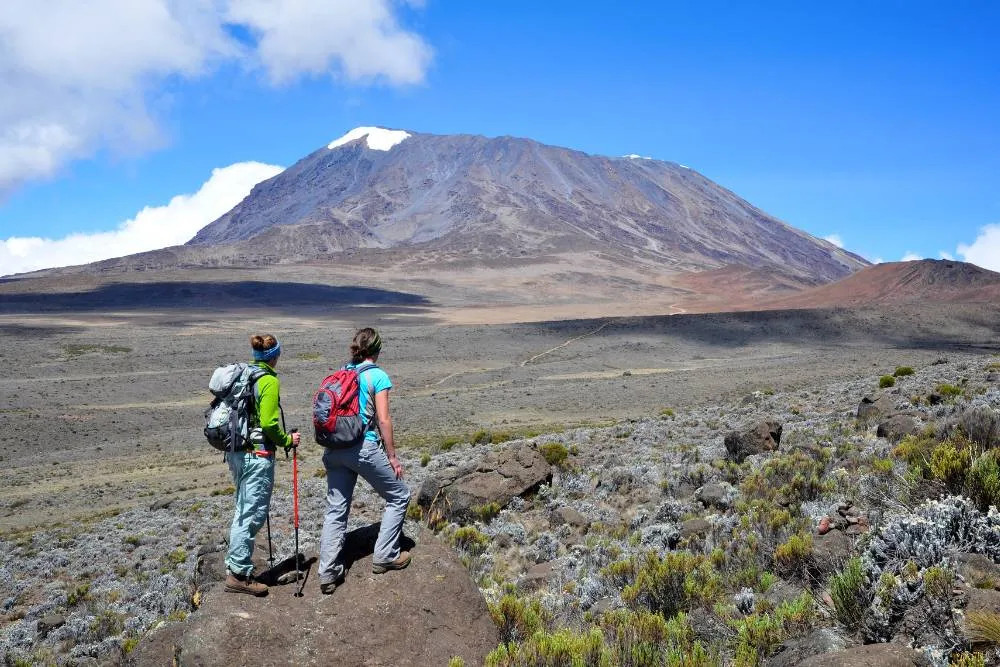 Two hikers at the foot of Mount Kilimanjaro — Getty Images