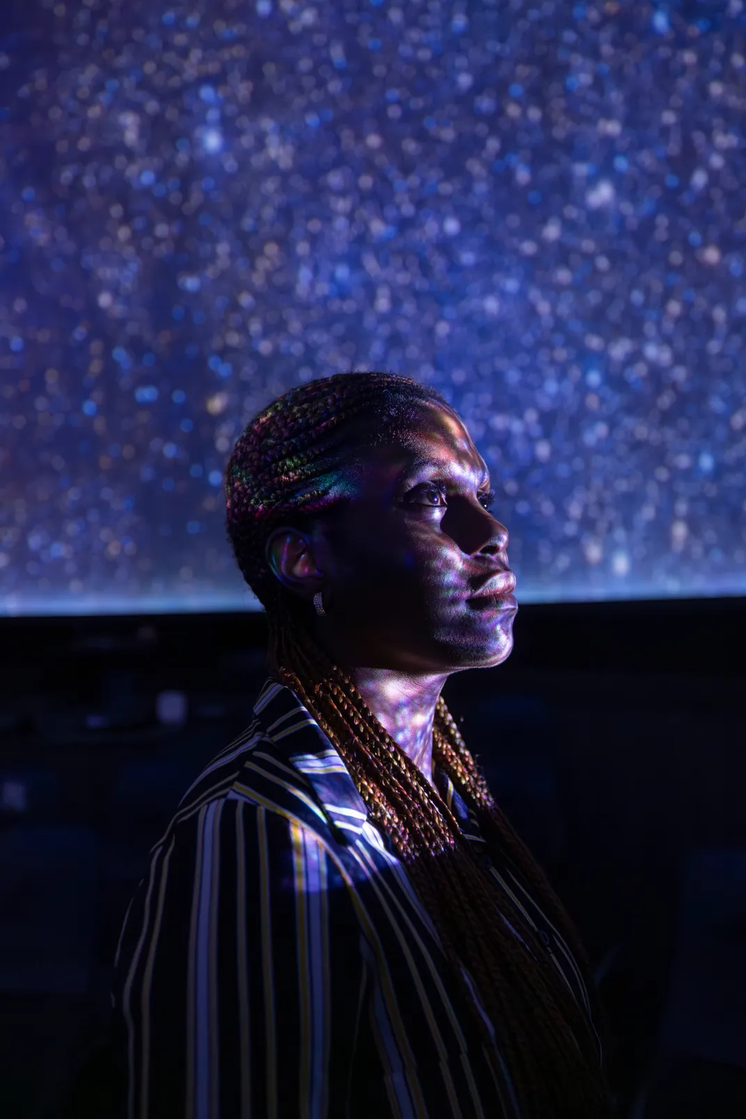 6 - At a planetarium, an operator takes a moment to appreciate the starry projection.