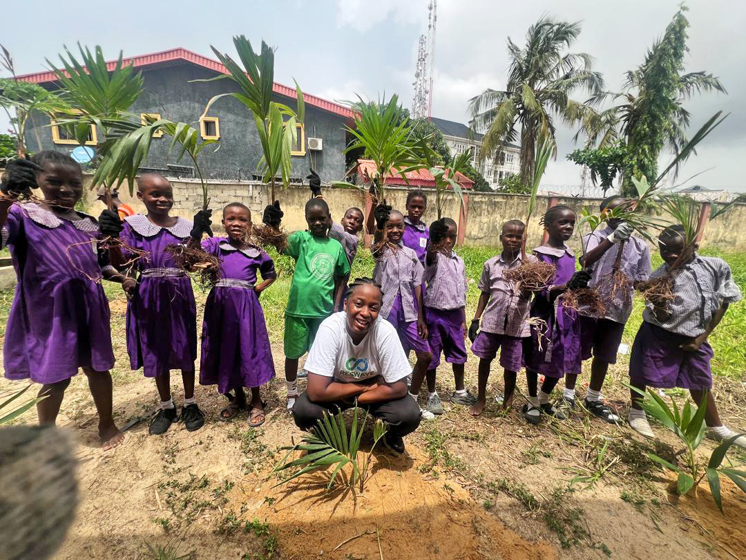 Doyinsola with school children planting trees.