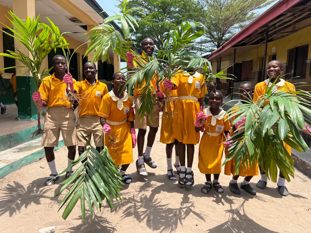 School children posing with saplings ready to be planted. 