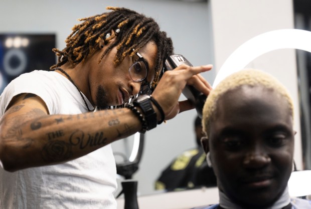 Barber Trey Johnson cleans up Kendrick Koffi's hair at the Cold Cutz Lounge, in the back room of the former Ultimate Look Barber, now known as the Powder Room, where he rents a chair, in St. Paul on Thursday, Oct., 3. 2024. (John Autey / Pioneer Press)