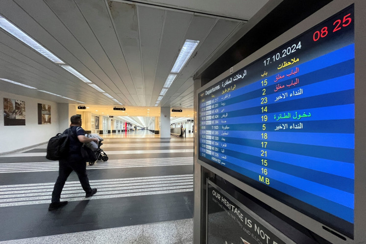 A man walks next to a flight information board at the Beirut–Rafic Hariri International Airport in Beirut, Lebanon, on Oct. 17, 2024.